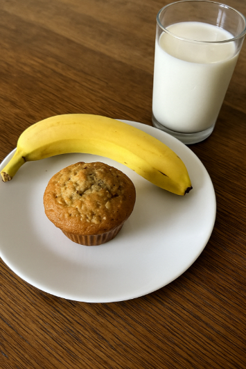 Banana muffin with a banana on a plate.